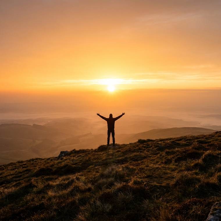 A figure at sunrise with arms raised